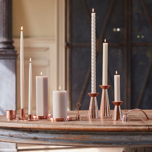 Our copper grand taper holders offer a modern take on a classic object, instantly elevating any setting. The luminous copper finish reflects light and lends a sense of movement to a table or mantlepiece, especially when paired or gathered as a trio. Each copper plated holder is sized to fit a standard taper candle.