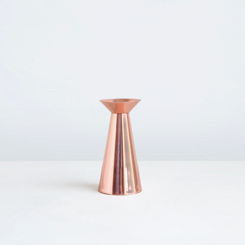 Our copper grand taper holders offer a modern take on a classic object, instantly elevating any setting. The luminous copper finish reflects light and lends a sense of movement to a table or mantlepiece, especially when paired or gathered as a trio. Each copper plated holder is sized to fit a standard taper candle.