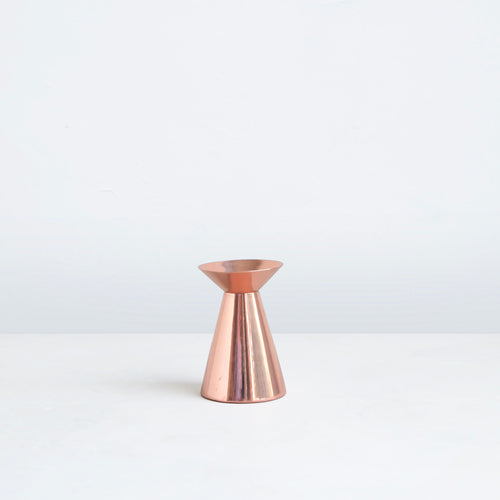 Our copper grand taper holders offer a modern take on a classic object, instantly elevating any setting. The luminous copper finish reflects light and lends a sense of movement to a table or mantlepiece, especially when paired or gathered as a trio. Each copper plated holder is sized to fit a standard taper candle.